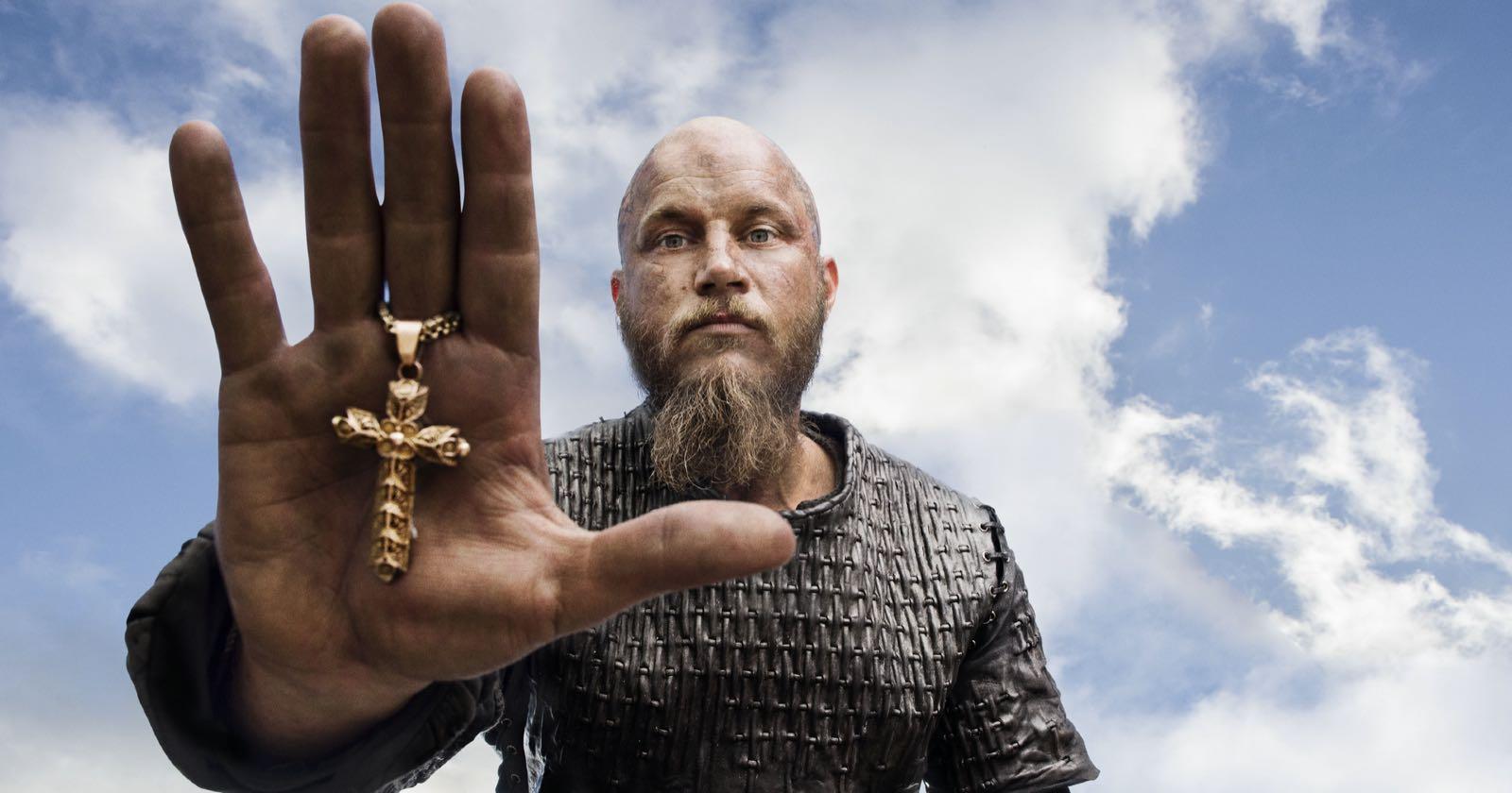 Ragnar Lothbrok, de origen Nórdico, con una cruz cristiana en su mano.