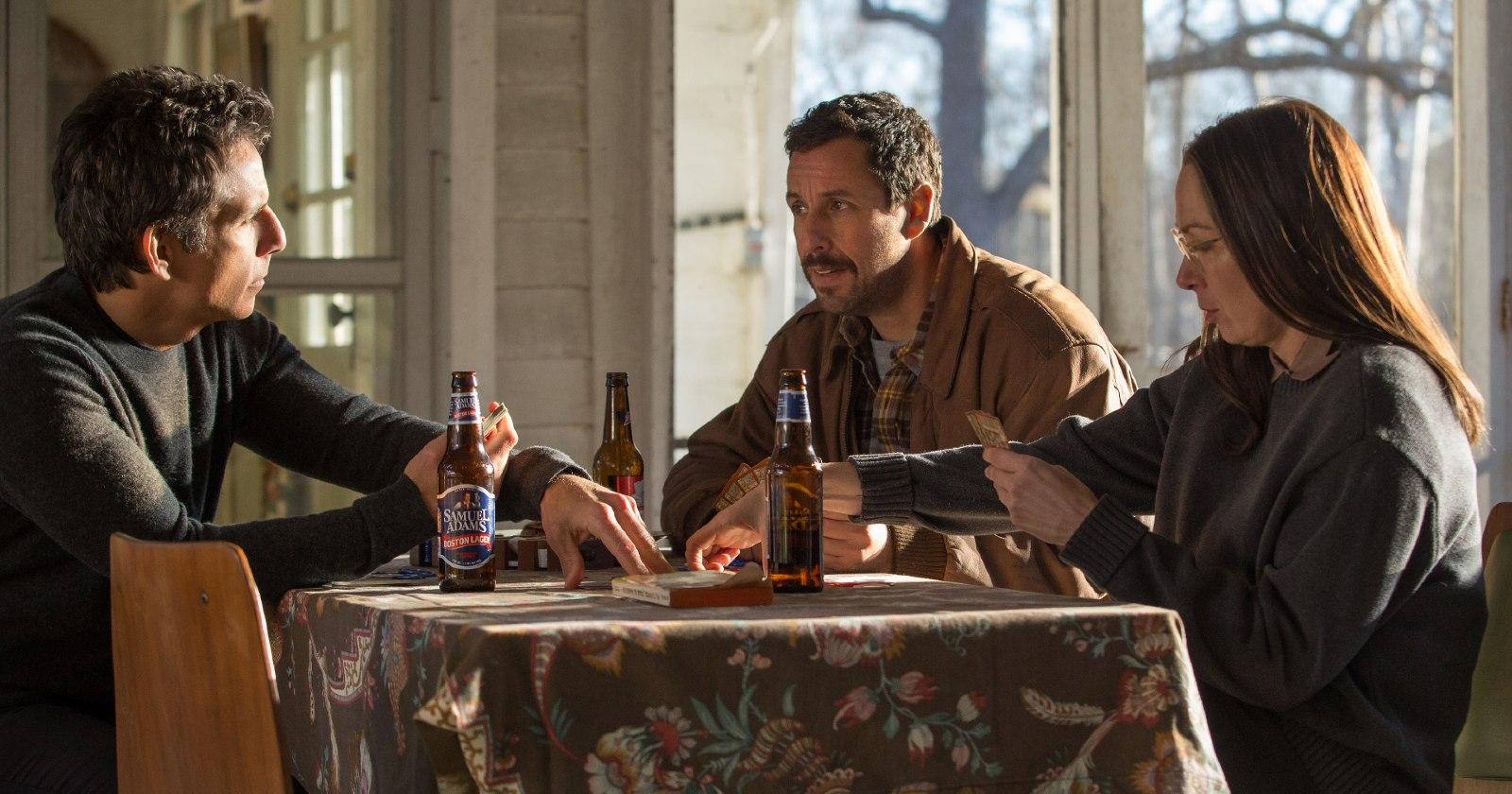 Danny Meyerowitz (Adam Sandler), Jean (Elizabeth Marvel) y Matthew Meyerowitz (Ben Stiller) en Los Meyerowitz: la familia no se elige (historias nuevas y selectas) sentados en una mesa mientras toman cervezas 