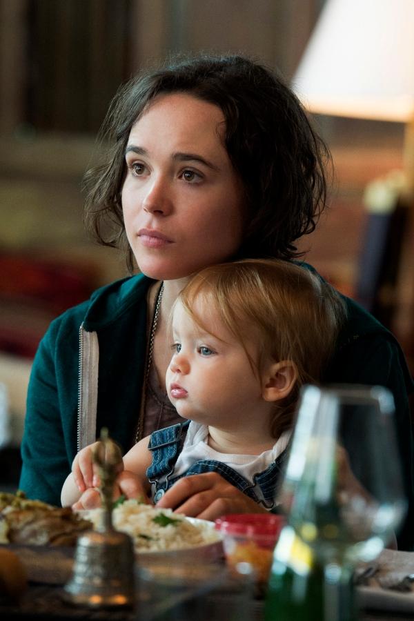 Elliot Page con una bebé en su regazo mientras comen en la película Tallulah