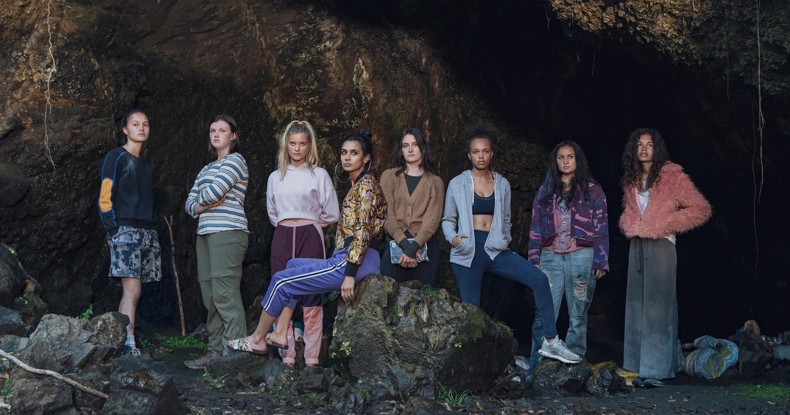 El elenco de Salvajes frente a una cueva. De izquierda a derecha: Toni, Dot, Shelby, Fatin, Leah, Rachel, Martha y Nora.