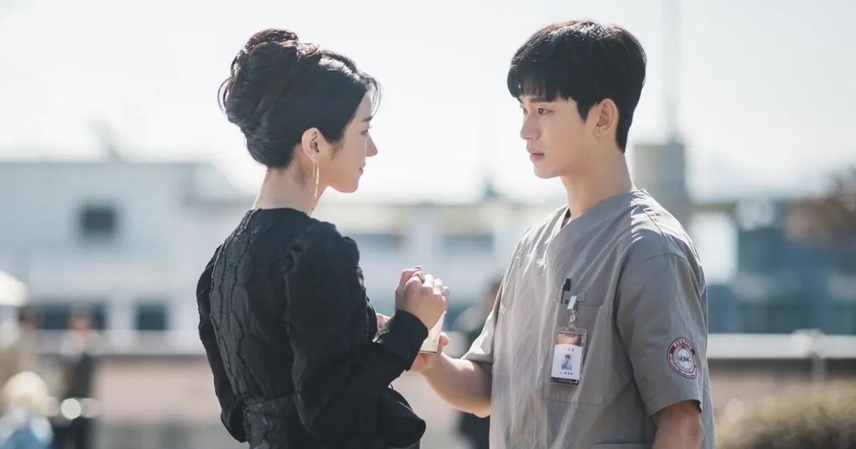 Protagonistas de la comedia romántica surcoreana Está bien no estar bien, tomados de la mano, mirándose de frente.